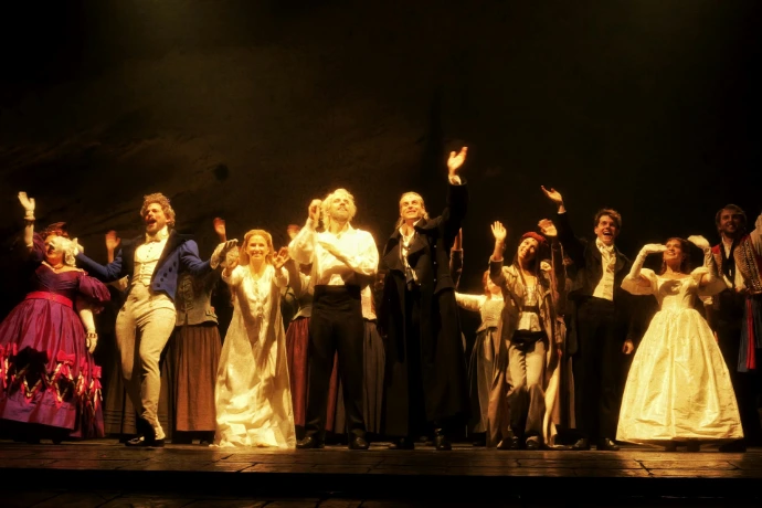 A group of people in historical costumes on stage.